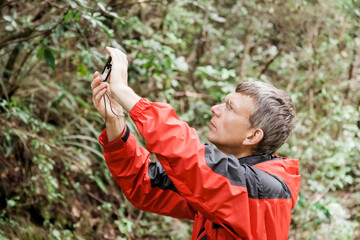 Mature man taking photos in forest