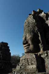 Fototapeta na wymiar The Bayon is a richly decorated Khmer temple with the multitude of serene and smiling stone face stands at the center of Angkor Thom, Siem Reap, Cambodia.