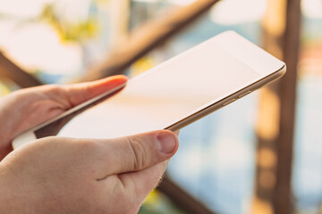 male hands holds digital pc t mock up for your text message or informational content, on the background of green nature