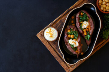  Baked sweet potato filled with kale and chickpeas . Top view with copy space