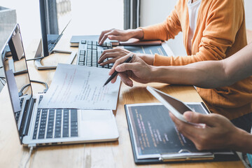 Writing codes and typing data code technology, Programmer cooperating working on web site project in a software developing on desktop computer at company, Programming with HTML, PHP and javascript