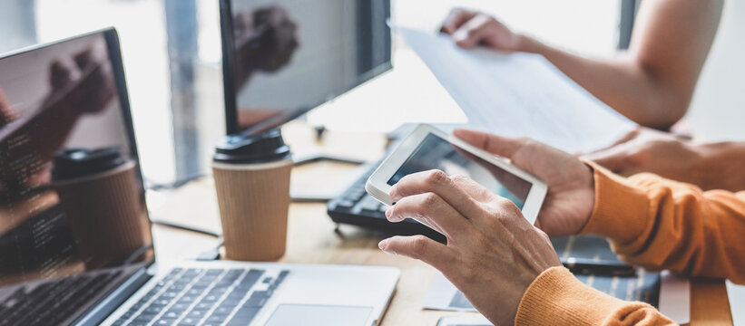 Writing codes and typing data code technology, Programmer cooperating working on web site project in a software developing on desktop computer at company, Programming with HTML, PHP and javascript