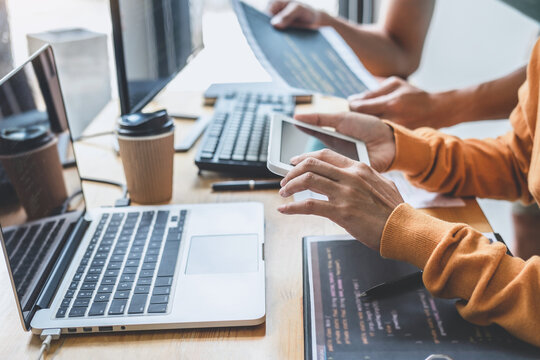 Two professional programmer cooperating and working on web site project in a software developing on desktop computer at company, codes and typing data code, Programming with HTML, PHP and javascript