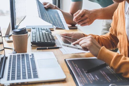 Programmers cooperating at Developing programming and website working in a software develop company office, writing codes and typing data code, Programming with HTML, PHP and javascript