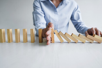 Risk and strategy in business, Close up of business woman hand stopping wooden block between three...
