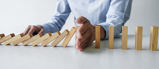Risk and strategy in business, Close up of business woman hand stopping wooden block between three...