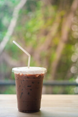 Iced coffee Mocha in disposable plastic cup on wood table