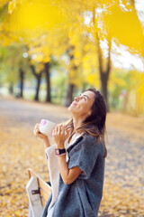 woman drinking coffee in autumn park