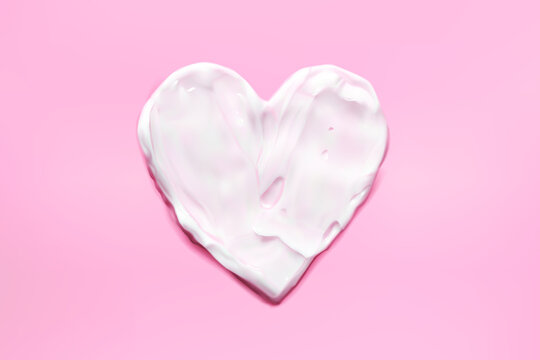 Heart moisturizer cream smear on pink background realistic illustration, top view. Concept skincare. Lotion for face or body