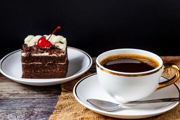Hot black coffee in a white mug served with brownie cakes.