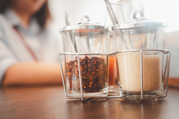Thai style noodles seasoning set, cayenne pepper and brown sugar with blur of woman background