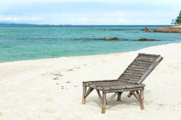 Fototapeta na wymiar Wooden beach chair on white sand beach in Thailand.