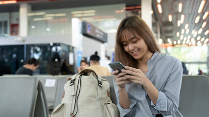 young woman talking on phone waiting for flying at airport. Airport Young female passenger on smart phone  sitting in terminal hall while waiting for her flight.