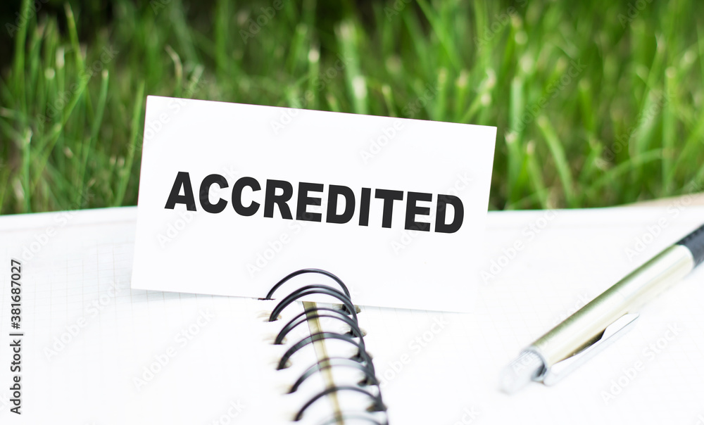 Poster card with accredited text on notepad and pen