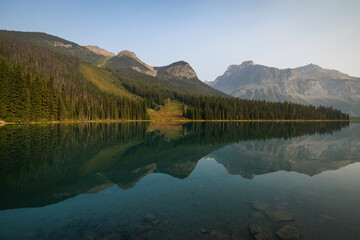 Fototapeta premium The mountains and trees reflected at Emerald Lake over at Yoho National Park in British Columbia, Canada