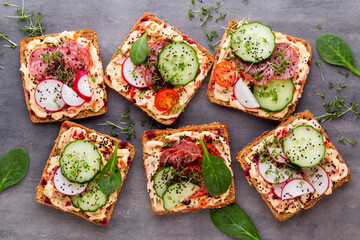 Sandwiches with cream cheese, vegetables and salami.