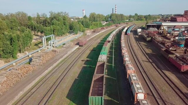 Sorting and recycling of metal waste top view. Station procurement of scrap metal. Loading operations for the disposal of ferrous metals passing cars and trains on the railway.