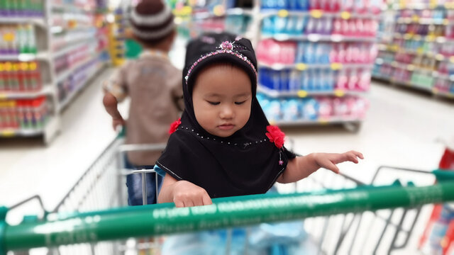 cute baby Muslim on the troller in shopping  supermarket blur background