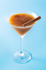 Pumpkin cocktail in glass on blue background