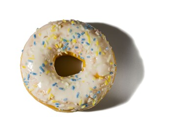 Close up view of donut sprinkled with multicolored glaze isolated on white  background. Food and drink concept.