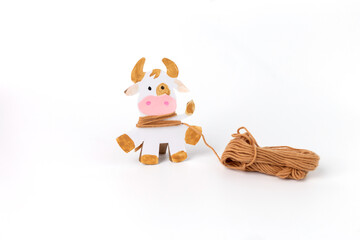 Step by step instructions for creating a paper cow or bull, Children art project. DIY concept. cardboard craft. Step 4. wrap the figure with threads