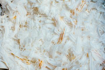 Fresh coconut flakes background. Detail of dried shaved coconut flakes.
