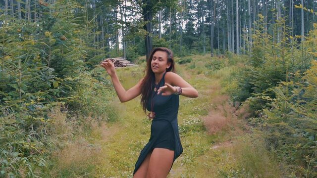 Native American Indian Woman Dancing Amongst the Trees in Forest Wearing a Tight Black Dress. Gorgeous girl