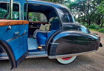 Back seat of luxury, classic, vintage car with plush seats, chrome details wine bottle and glasses...
