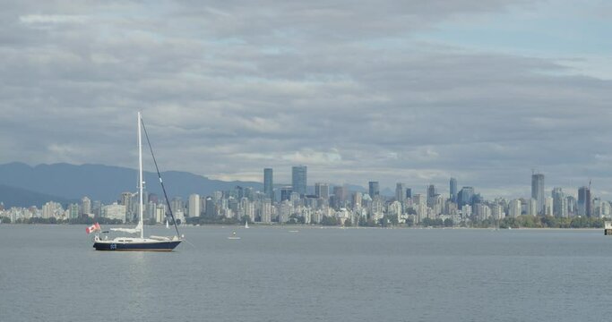 Sailboat & downtown Vancouver cityscape with moving clouds.