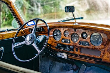 Interior dashboard of luxury, vintage, classic car with wood panelling.