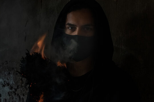 YOUNG MAN WITH FIRE TORCH IN URBAN EXPLORATION URBEX