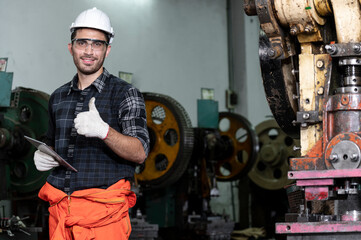 smile engineer checking and inspects quality of industrail machine in factory with confident
