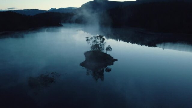 Drone video of a foggy lake captured during the night in Norway.