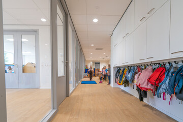 ARNHE, NETHERLANDS - Aug 28, 2020: Cloakroom with coats and backpacks in a school building for toddlers and young children