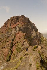 Fototapeta na wymiar Climbing to the dramatic peak of Pico Ruivo mountain on the ridge of Madeira Island, Portugal