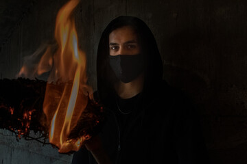 Fototapeta na wymiar YOUNG MAN WITH FIRE TORCH IN URBAN EXPLORATION URBEX