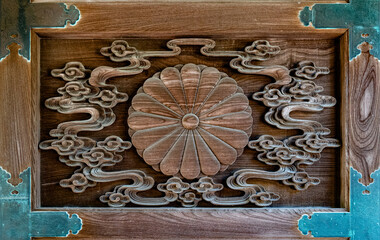 A chrysanthemum crest in the wooden door of the Japanese temple 
