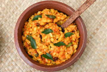 Popular traditional South Indian food cooked young jackfruit /  jakfruit  / jack /  jak with turmeric, chilly, grated coconut in earthen ware Kerala, India. served with fish curry. Indian food, spices