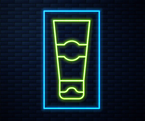 Glowing neon line Tube of toothpaste icon isolated on brick wall background. Vector.