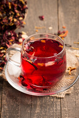 Cup of fresh red tea on wooden background