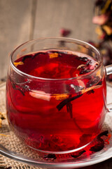 Cup of fresh red tea on wooden background
