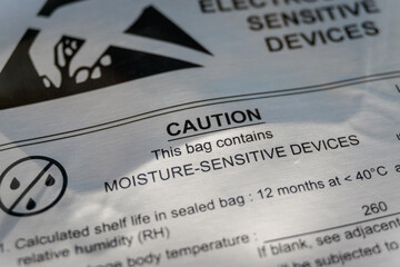 Close-up of moisture barrier bag caution warning label from electronics manufacturing industry