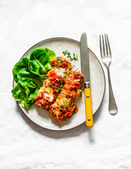 Roasted zucchini cannelloni meat filling with tomato sauce, thyme and mozzarella cheese on a light background, top view