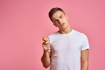 Man with fruits in hands on a pink background healthy food vitamins pink background white t-shirt model