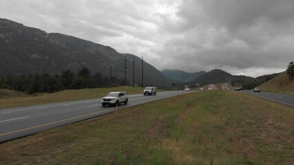 Meridian aerial of traffic on divided mountain highway in heavy cloud