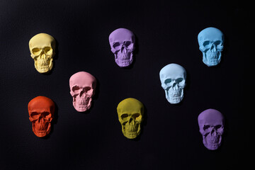 Rainbow color sculls on black background. Halloween flat background.