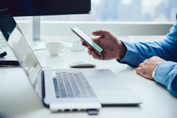 Unrecognizable man with smartphone in office