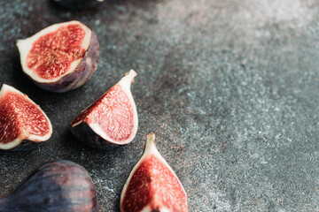 Macro photography of fresh ripe cutted figs on the textured background.