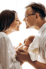 Happy young family with little daughter, beautiful mother hold cute newborn baby in arms, caring...
