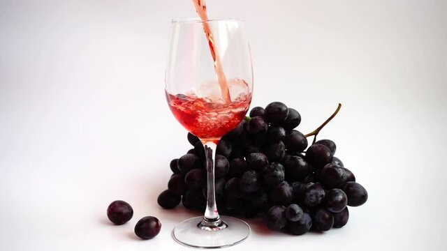 Pouring wine into a glass on a white background.